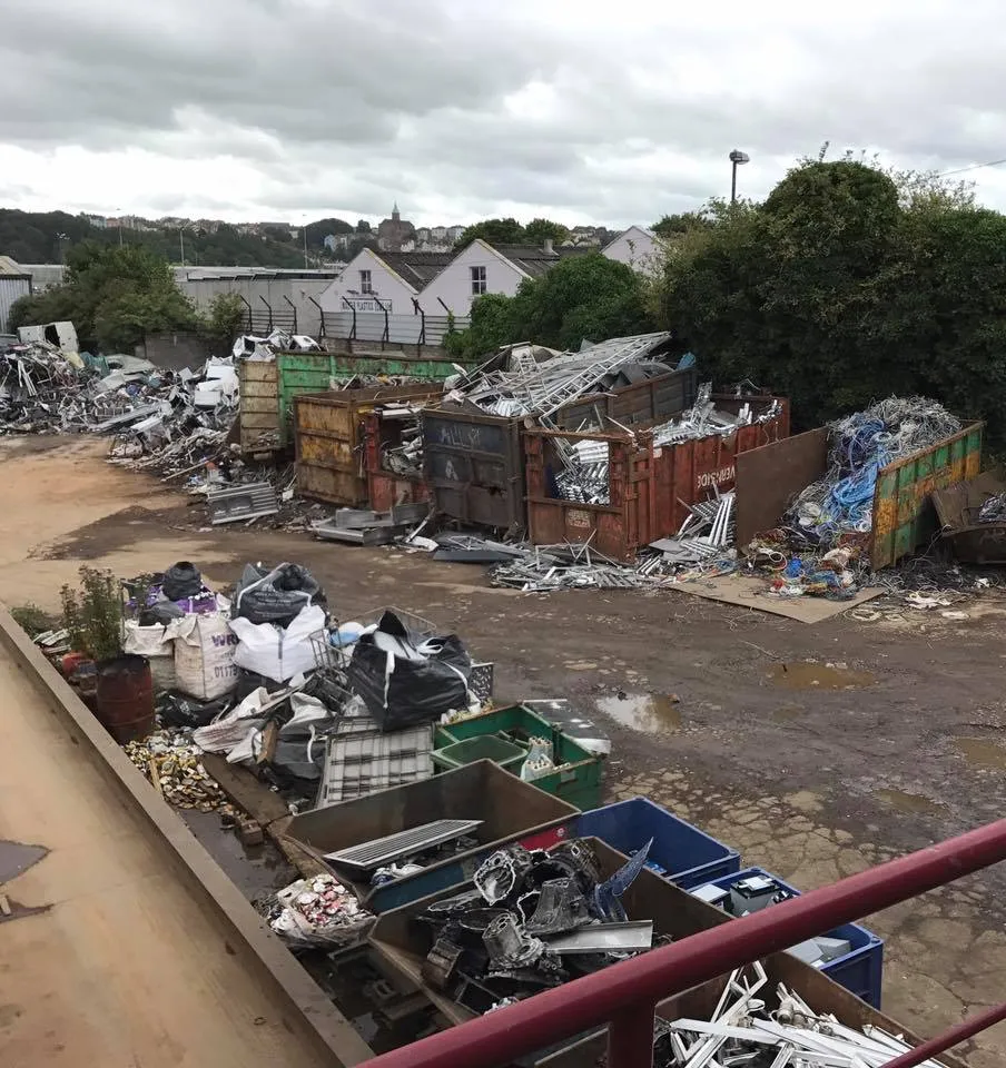 view of scrap yard and vehicles
